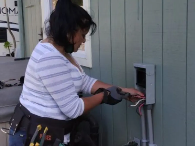 Licensed electrician wiring an exterior subpanel in West Point